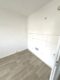 2-Zimmer-Wohnung mit Balkon und Teleheizung in Borna - Leere Küche mit Fliesenwand